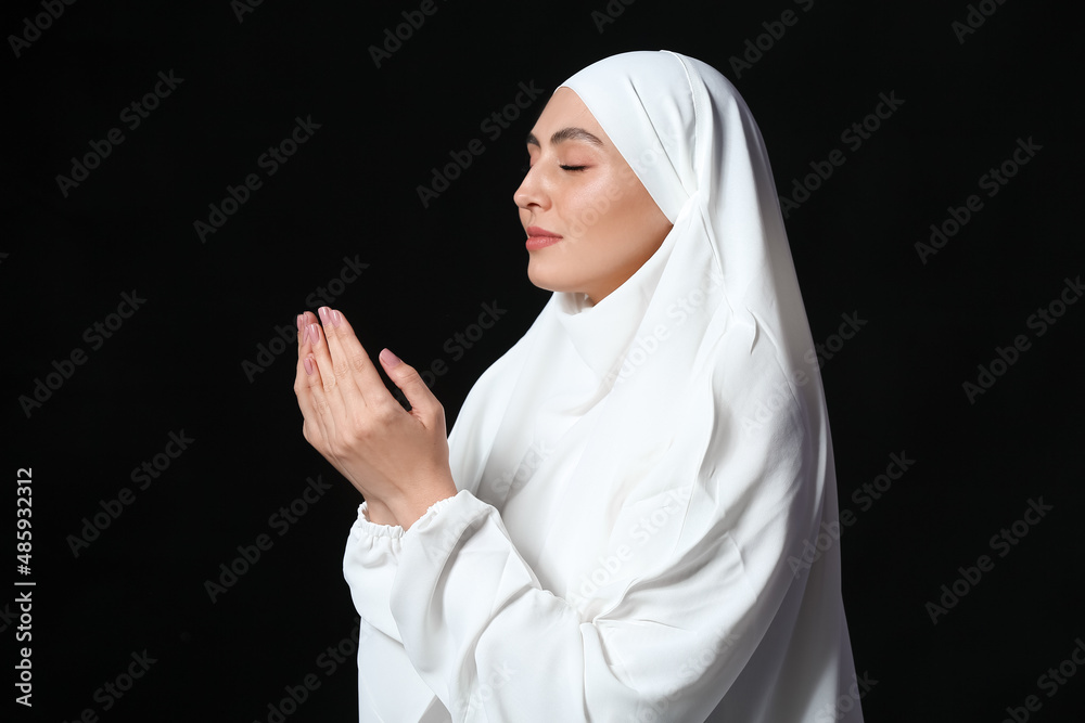 Muslim woman praying on dark background