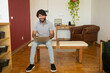 © Buonaventura - Young business man working at home from his living room chair with laptop on his lap. Home office concept. Gray notebook for working. Home office concept. High quality photo