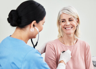Poster - Living life with a positive attitude and a healthy heart. Shot of a female doctor examining a patient with a stethoscope.