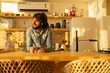 © Buonaventura - View of young man listening to music with headphones in his ears in the kitchen of his apartment. High quality photo.