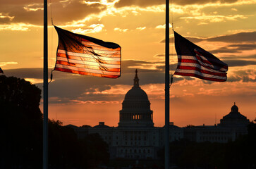 Wall Mural - United States National flags and capitol building in silhouettes during sunrise - Washington D.C.  United States