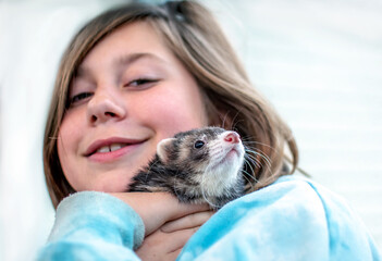 young girl hugging her pet  ferret