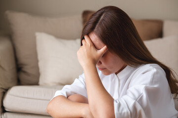 Wall Mural - A young asian woman feeling sad and stressed, sick and headache at home