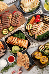 Wall Mural - Grilled fish, seafood and meat assortment on light background.