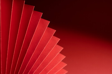 Wall Mural - A closeup shot of Chinese style paper folding fan isolated on red background