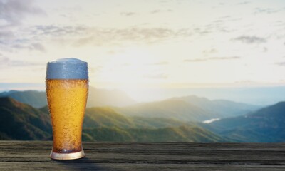 Draft or craft beer in clear glass with beer foam on top Put on set of wooden tables and chairs. Lounge seating on the wooden terrace with mountain background with god light or sunlight.3d rendering