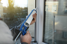 Construction Worker Sealing Window With Caulk Indoors, Closeup
