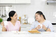 © offsuperphoto - mother feeding apple to down syndrome teenage girl or her daughter and eating breakfast together in a kitchen