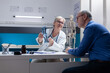 © DC Studio - Woman doctor explaining x ray scan diagnosis to patient with illness at medical appointment. Healthcare specialist showing radiography results to sick man at annual checkup visit.