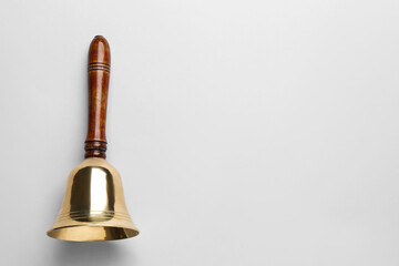 Wall Mural - Golden school bell with wooden handle on grey background, top view. Space for text