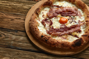 Wall Mural - Carbonara pizza with bacon and egg on wooden background