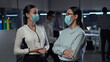 © nimito - Portrait of diverse businesswomen in safety mask standing in office and chatting