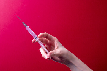 female hand holding a medical syringe