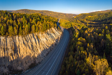 Wall Mural - Aerial view of the highway among the autumn forest