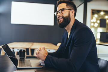 Thoughtful businessman sitting alone in an office