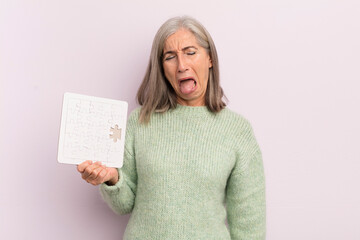 Wall Mural - middle age woman with cheerful and rebellious attitude, joking and sticking tongue out. puzzle challenge concept