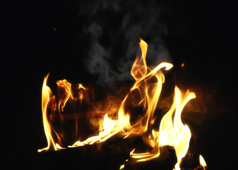 Smoke flames of burning firewood in the fireplace of a country house. Coals and sparks.