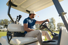 Golfer Riding Golf Cart On Golf Field At Sunny Day