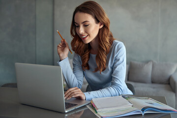 Wall Mural - Young caucasian girl doing homework at home