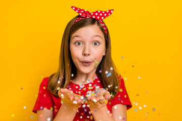 Sticker - Photo of cute positive little teen woman blow send you confetti celebrate birthday isolated on yellow color background