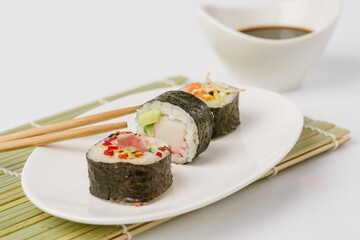 Wall Mural - Maki Sushi Rolls set on wooden board. Japanese traditional Cuisine. White background.