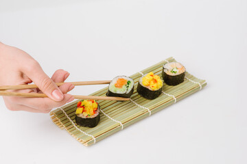 Wall Mural - Maki Sushi Rolls set on wooden board. Japanese traditional Cuisine. White background.