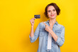 Photo of young pretty girl indicate finger credit card select promo proposition isolated over yellow color background