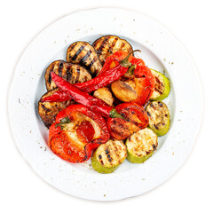 Grilled roasted vegetables on a white plate.  Sweet peppers, tomatoes, zucchini, eggplant. Top view