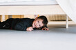 © 23_stockphotography - elementary happy caucasian child hiding under the bed