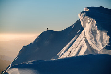 Awesome scenic view of the beautiful relief snow-covered mountain slope and freeriding skier on it