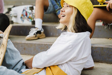 Asian Girl Laughing While Spending Time With Her Friends At Skate Park