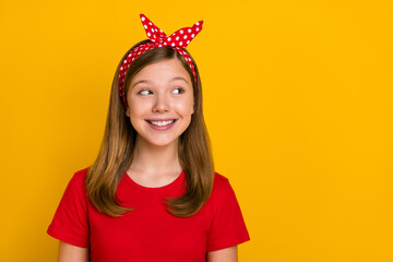 Wall Mural - Photo of cute teenager girl look empty space wear red t-shirt headband isolated on yellow color background