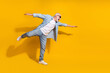 © deagreez - Full length body size view of attractive cheerful motivated grey-haired man having fun flying isolated on bright yellow color background