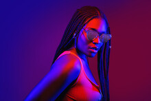 Portrait Of Fashion Young Girl In Cool Sunglasses In Red And Blue Neon Light In The Studio