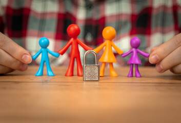 Family problems, plastic colorful figurines on wooden table with padlock. Divorce in family with children, conflict, crisis concept photo