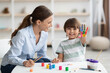© Prostock-studio - Happy little boy showing colorful palm, smiling to camera, sitting with professional psychologist during art therapy