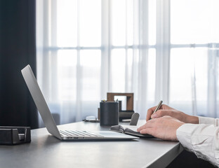 Poster - Hands taking notes, writing in planner, notebook at office desk with laptop computer. High quality photo