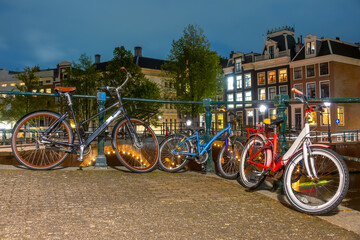 Wall Mural - Cycling Family :) on the Canal Embankment in Amsterdam at Night