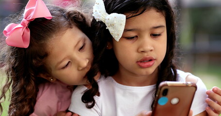 Little girls staring at cellphone screen. children on social media