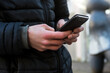 © pixarno - Closeup of smartphone in hand of young man standing in the street