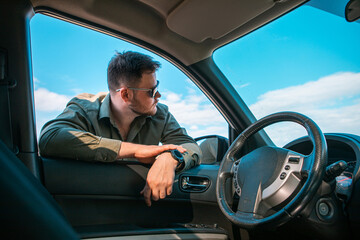 handsome strong man portrait near the car