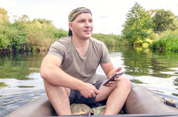 Young man sitting in a boat outdoors.