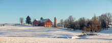 Amish Farm With Red Barn Sitting On A Snow Covered Hill In Holmes County, Ohio