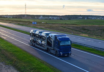 Car carrier trailer transports cars on highway. Auto transport and car shipping services concept. Truck with Semi-remorque. Cars Shipping and transporter.