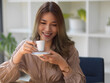 © bongkarn - Woman holds a coffee set and sips hot morning coffee