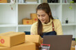 © bongkarn - Female entrepreneur prepare packing a delivery package of her customers.