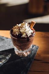 Poster - A hot chocolate topped with whipped cream, chocolate drizzle, cinnamon stick on wood table