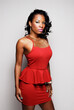  Portrait of a beautiful young African American woman with glowing skin wearing a red top and skirt. 