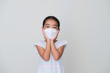 Wall Mural - Asian kid showing happy expression while wearing medical mask during pandemic
