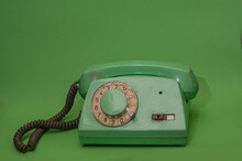 Old Green Retro Vintage Phone On Green Background. Minimalistic, Monochromatic Composition 

